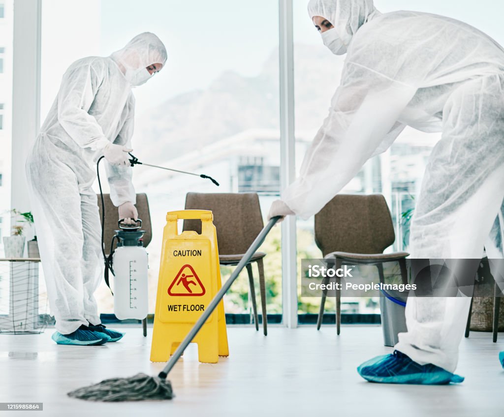 Control corona and keep it clean Shot of healthcare workers wearing hazmat suits and sanitising a room during an outbreak Cleaning Stock Photo