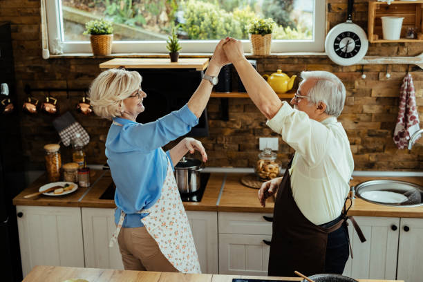 istock Happy mature husband and wife having fun while dancing in the kitchen. 1215986021