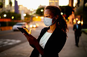 Businesswoman outdoors wearing healthcare mask.