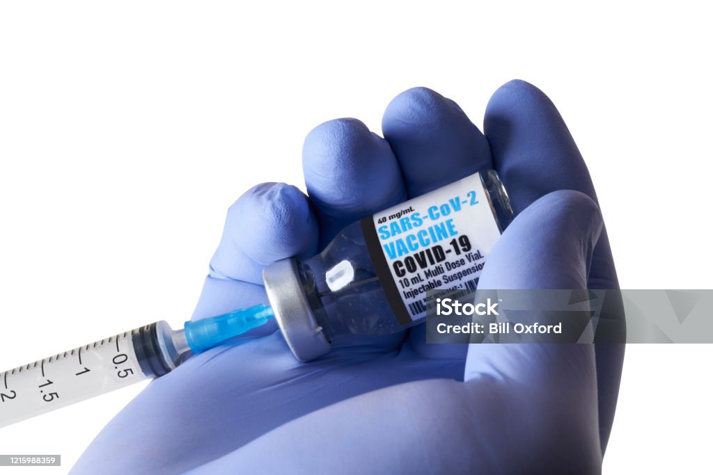 Vaccine: Covid-19, Coronavirus in vial with syringe on white background. Vaccine: Covid-19, Coronavirus in vial with syringe on white background. Fake label. Hand Stock Photo
