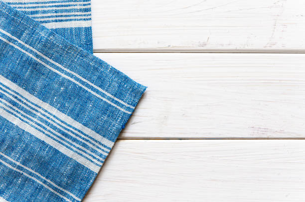 istock A blue napkin in a white stripe rests on a white wooden table 1215989294