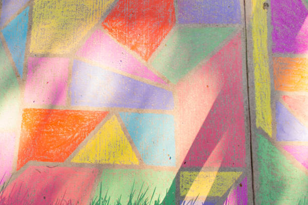 A vibrant pink star drawn with colorful chalk on textured pavement showcases childhood creativity and playfulness, inviting all to appreciate the outdoor artistry
