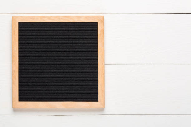 白い木の背景に空の黒いレターボード。モックアップをデザインする - felt textured textured effect textile ストックフォトと画像