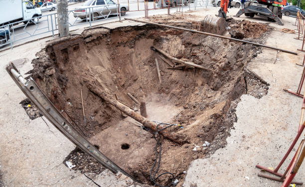 istock Construction works on rusty iron pipes at a depth of excavated trench 1215993577