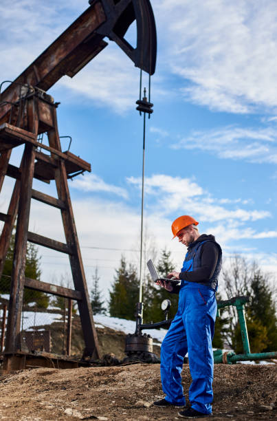 istock Petroleum engineer with laptop working in oil field. 1215993722
