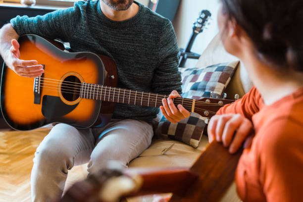 istock Unrecognizable guitar teacher explaining a music class to female student. 1215994366