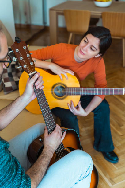istock vertical view of music male teacher changing guitar strings. 1215994643