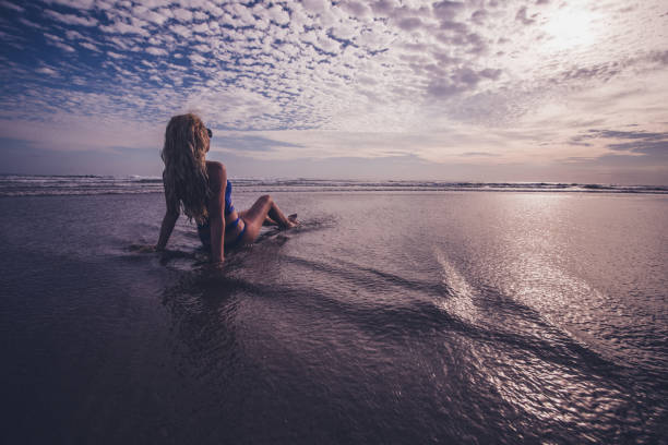 istock Blondie female relaxing in ocean wave at sunrise. 1215997099