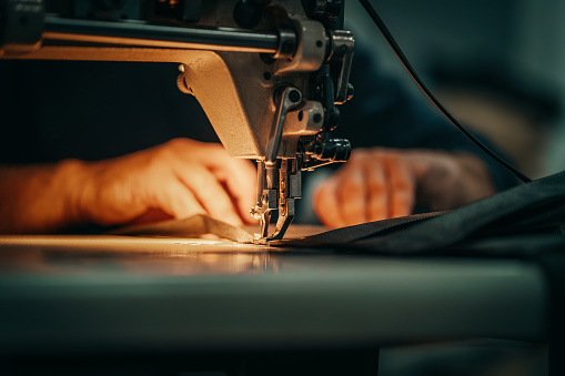 Máquina de coser y manos de hombre de un sastre photo