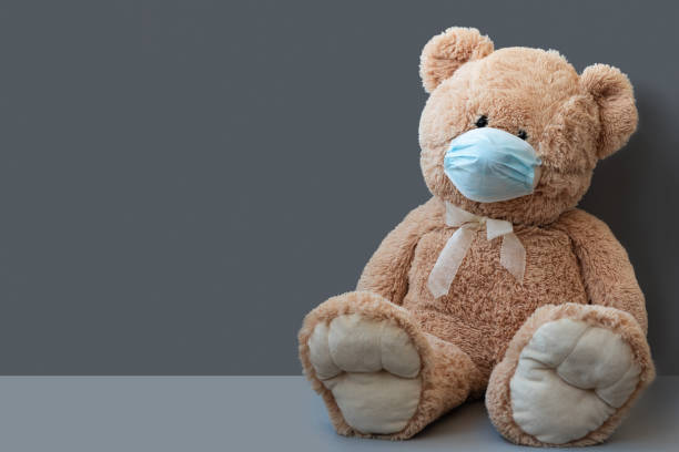 istock COVID-19 quarantine. Teddy bear wearing protective mask on gray background. Selective focus. Flu, illness, pandemic concept 1215997974