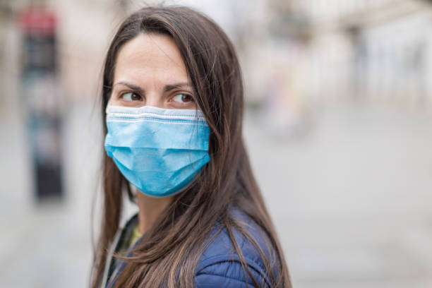 istock Woman with a face protective mask looking scared 1216006166