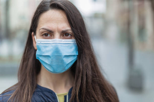 istock Woman with a face protective mask looking scared 1216006171