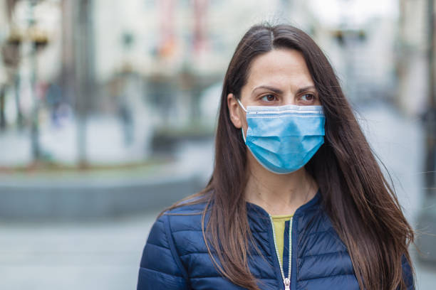istock Woman with a face protective mask looking scared 1216007005