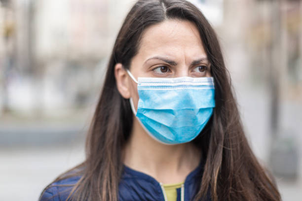 istock Woman with a face protective mask looking scared 1216007381