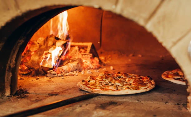 pizza italiana é cozida em um forno a lenha. - healthy eating italian culture traditional culture close up - fotografias e filmes do acervo