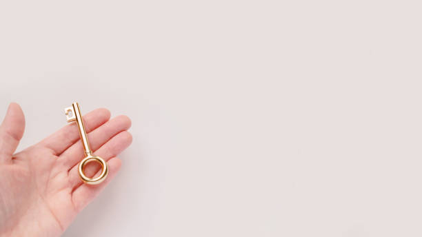 istock Gold key in woman hand 1216010181