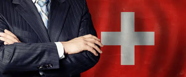 Politician crossed arms of on Swiss flag background