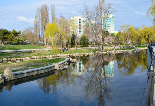 Beautiful cityscape: high-rise buildings, river, trees. Simferopol, view of the Salgir river.