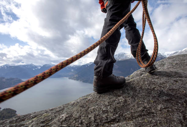 istock Mountaineer walks along mountain ridge with climbing rope 1216013356