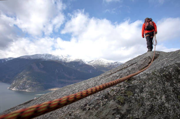 istock Mountaineer walks along mountain ridge with climbing rope 1216013357