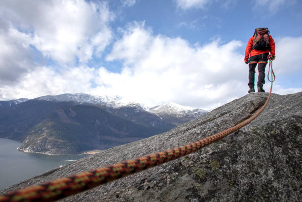 istock Mountaineer walks along mountain ridge with climbing rope 1216013396