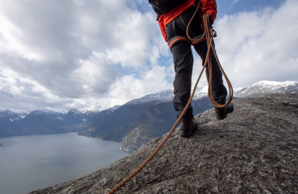 istock Mountaineer walks along mountain ridge with climbing rope 1216013431