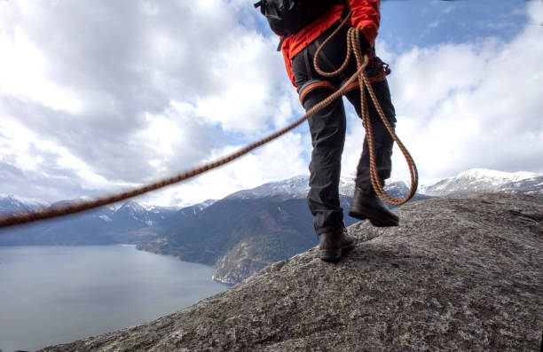 istock Mountaineer walks along mountain ridge with climbing rope 1216013470