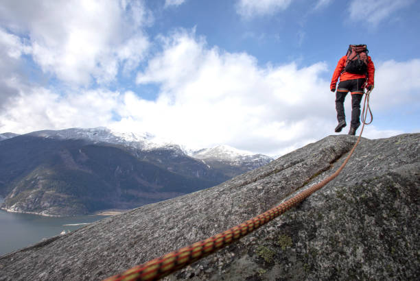 istock Mountaineer walks along mountain ridge with climbing rope 1216013551