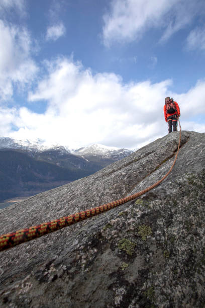 istock Mountaineer walks along mountain ridge with climbing rope 1216013600