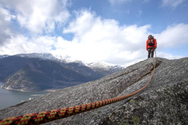 istock Mountaineer walks along mountain ridge with climbing rope 1216013641