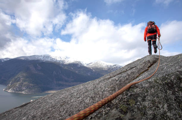 istock Mountaineer walks along mountain ridge with climbing rope 1216013673