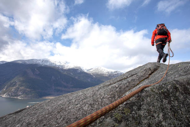 istock Mountaineer walks along mountain ridge with climbing rope 1216013718