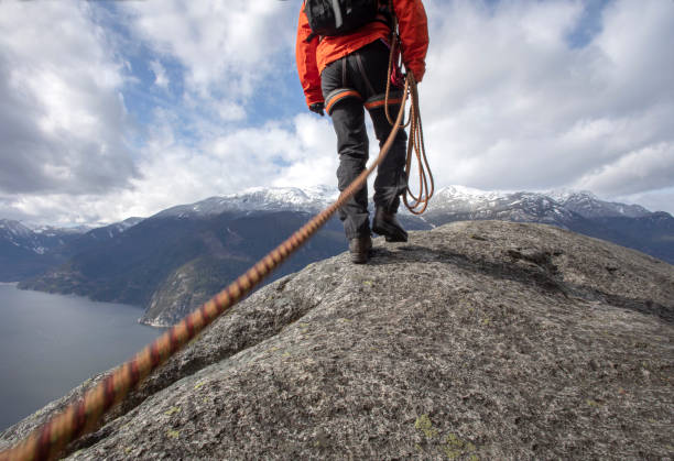istock Mountaineer walks along mountain ridge with climbing rope 1216013749