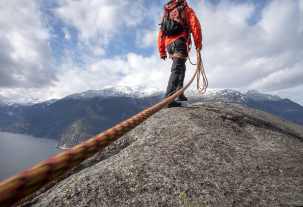 istock Mountaineer walks along mountain ridge with climbing rope 1216013752