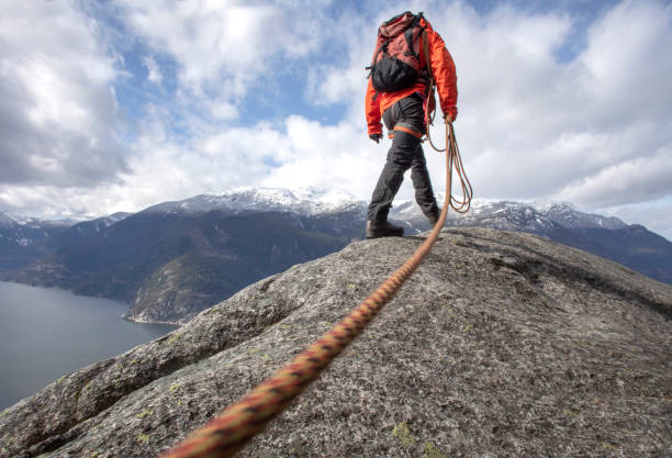 istock Mountaineer walks along mountain ridge with climbing rope 1216013799