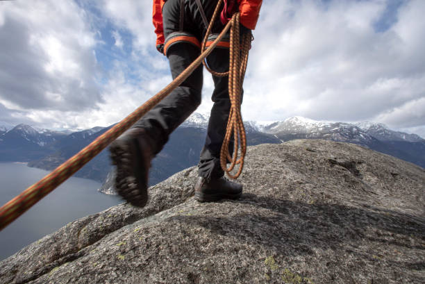 istock Mountaineer walks along mountain ridge with climbing rope 1216013808
