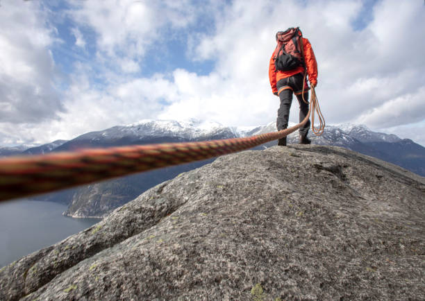 istock Mountaineer walks along mountain ridge with climbing rope 1216014367