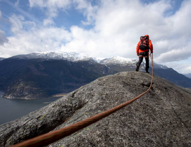 istock Mountaineer walks along mountain ridge with climbing rope 1216014399