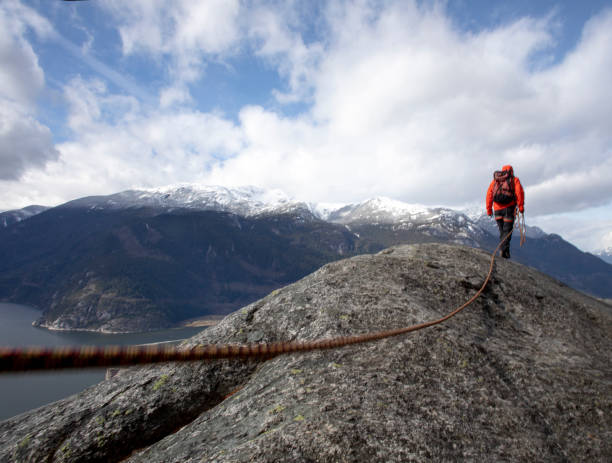 istock Mountaineer walks along mountain ridge with climbing rope 1216014425