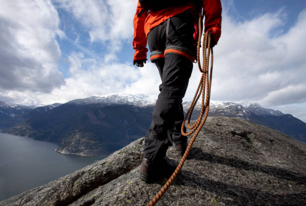 istock Mountaineer walks along mountain ridge with climbing rope 1216014428