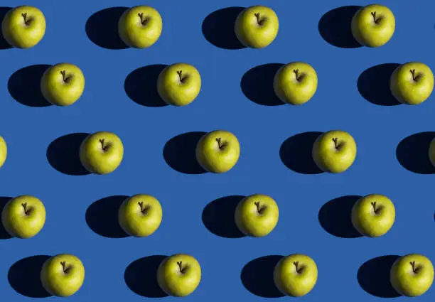 Colorful fruit pattern of yellow apple on blue background. Top view