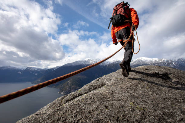 istock Mountaineer walks along mountain ridge with climbing rope 1216014469