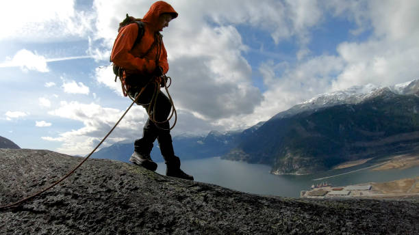 istock Mountaineer walks along mountain ridge with climbing rope 1216014470