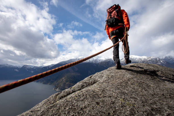 istock Mountaineer walks along mountain ridge with climbing rope 1216014498