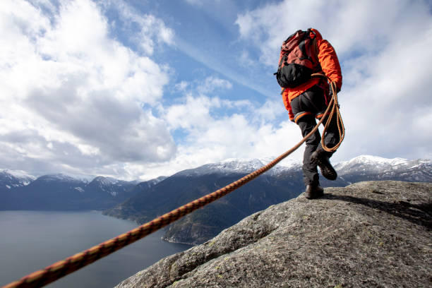 istock Mountaineer walks along mountain ridge with climbing rope 1216014528