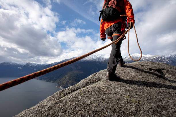 istock Mountaineer walks along mountain ridge with climbing rope 1216014547