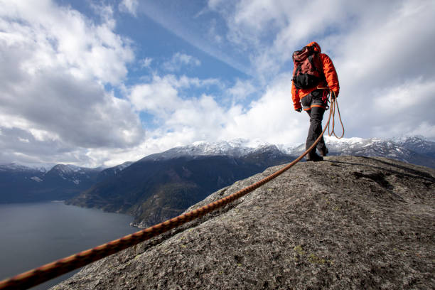 istock Mountaineer walks along mountain ridge with climbing rope 1216014549