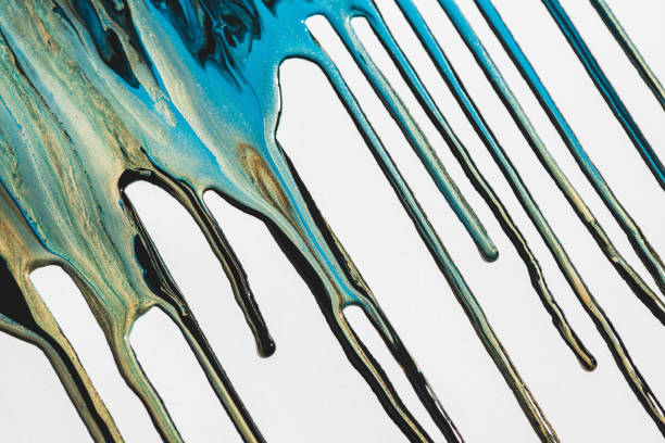 istock Liquid ink flows down white canvas. Fluid art background with mix of light blue and golden tints. Acrylic paints flows to down. Cyan gold abstract backdrop. Mixing of glitter colors. Aqua with gilding 1216014741