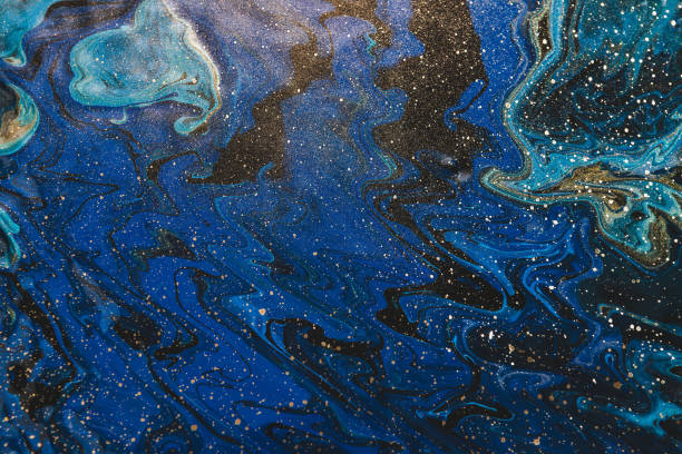 istock Fluid art background in blue tints with gilding. Flowing wave effect of liquid ink. Dark phantom blue with golden stains. Fantasy abstract texture of acrylic paints. Surreal color mix. Gold on blue. 1216014762