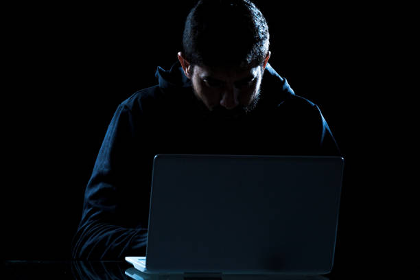 istock Dramatic shot of hacker using laptop in dark room 1216017551